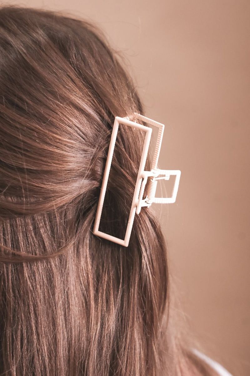 a metal neutral rectangular claw clip with a secure hold that reduces breakage in peach