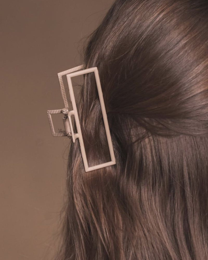a metal neutral rectangular claw clip with a secure hold that reduces breakage in tan