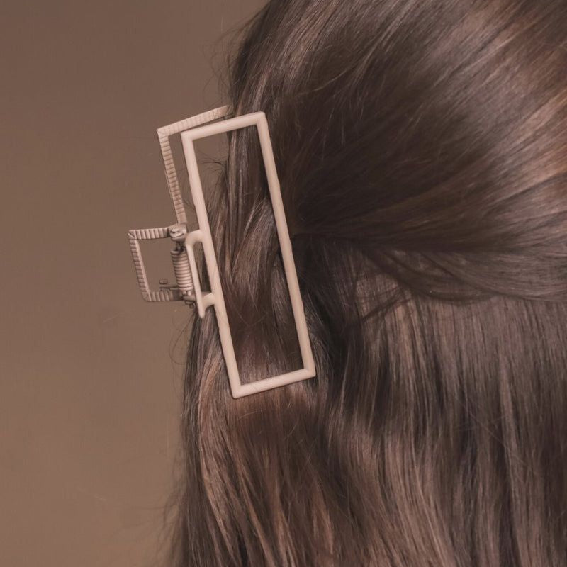 a metal neutral rectangular claw clip with a secure hold that reduces breakage in tan