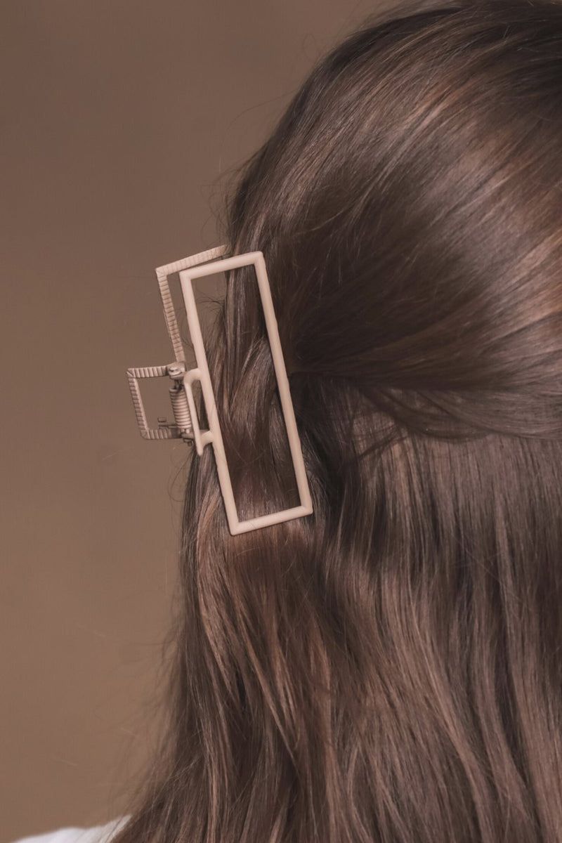 a metal neutral rectangular claw clip with a secure hold that reduces breakage in tan