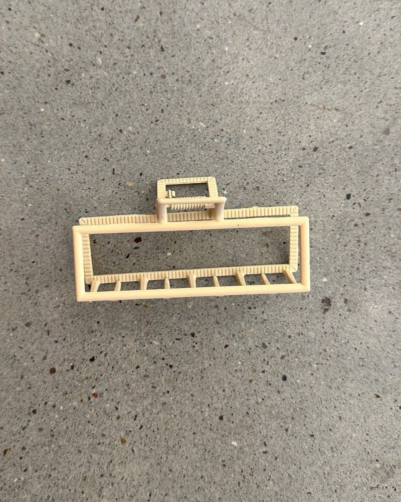 a metal neutral rectangular claw clip with a secure hold that reduces breakage in peach