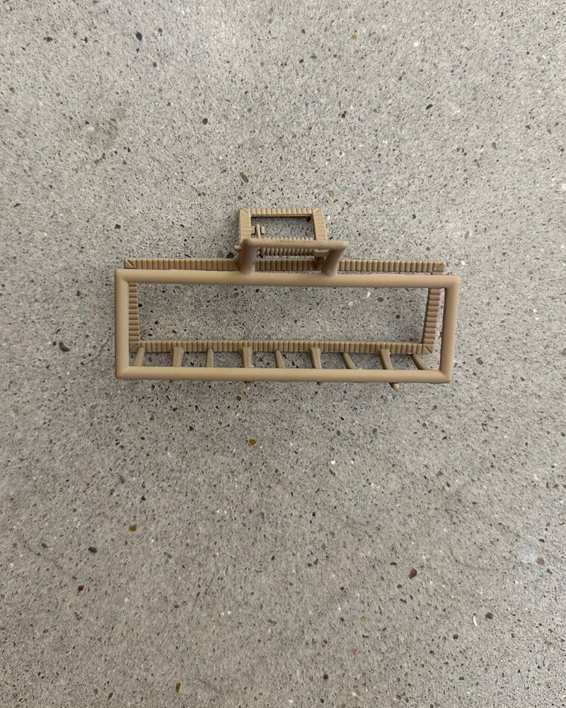 a metal neutral rectangular claw clip with a secure hold that reduces breakage in tan