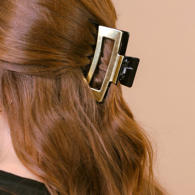 a metallic claw clip with a strong hold and sleek shine in gold