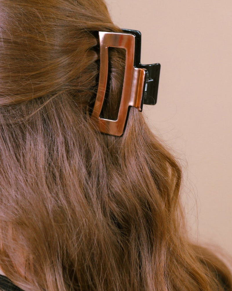 a metallic claw clip with a strong hold and sleek shine in rose gold