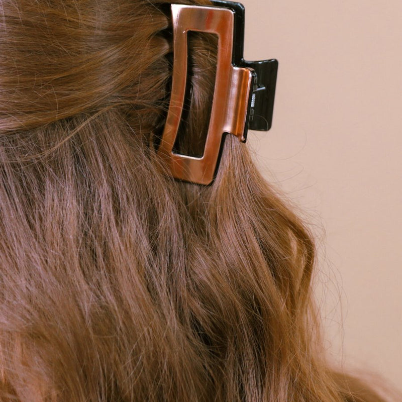 a metallic claw clip with a strong hold and sleek shine in rose gold