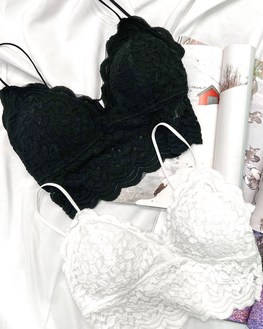 crochet lace bralette with a pullover style, a V-neckline, adjustable straps, and removable pads in black and ivory