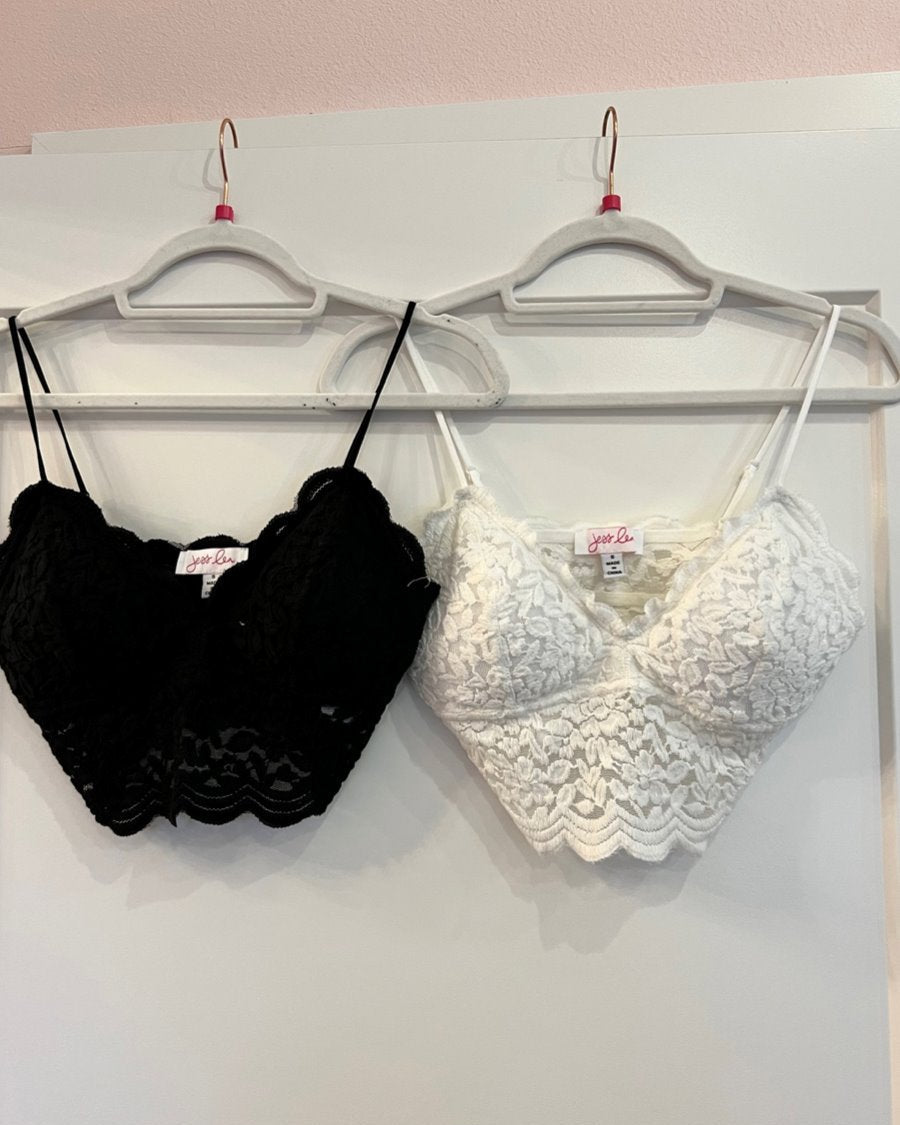 crochet lace bralette with a pullover style, a V-neckline, adjustable straps, and removable pads in black and ivory