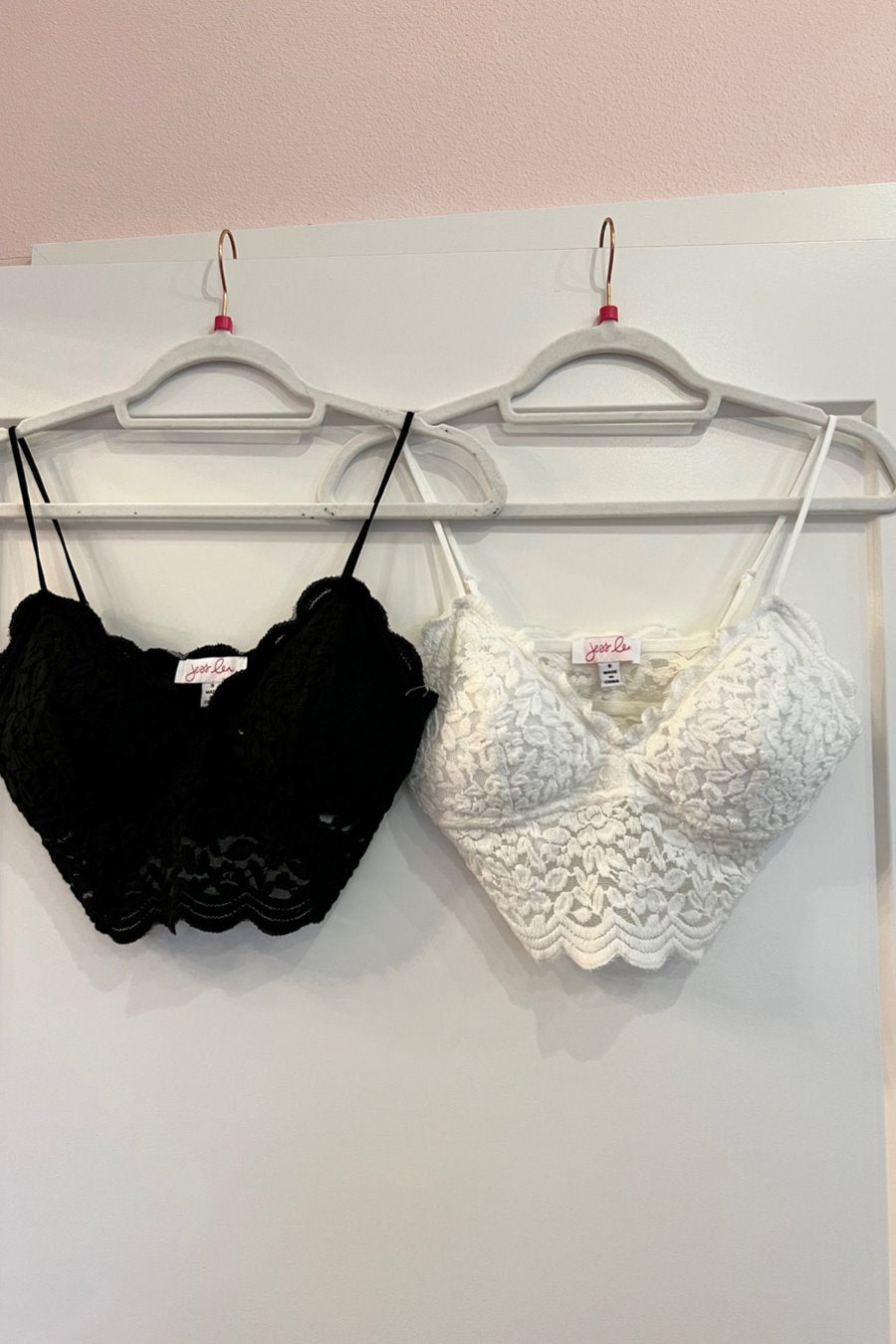 crochet lace bralette with a pullover style, a V-neckline, adjustable straps, and removable pads in black and ivory