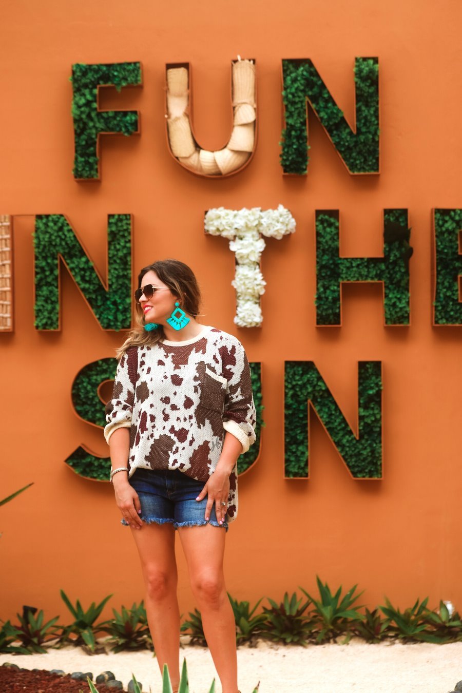 three-quarter cuffed sleeve unlined sweater crafted from a loose knit material with an oversized fit, a rounded neckline, a chest pocket, and trim on the collar, hem, and pocket on a brown cow print and cream base