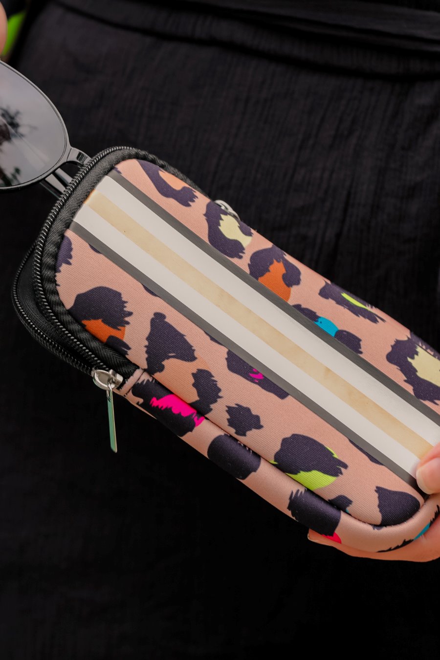 ultra-lightweight sunglasses case made of neoprene with a top double zipper in silver hardware and corresponding racing stripes in multi leopard