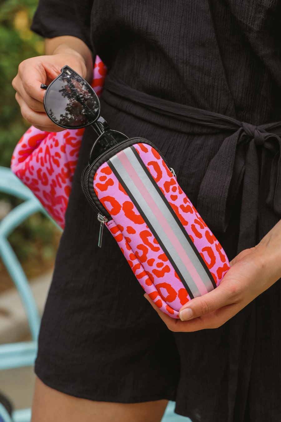 ultra-lightweight sunglasses case made of neoprene with a top double zipper in silver hardware and corresponding racing stripes in pink leopard