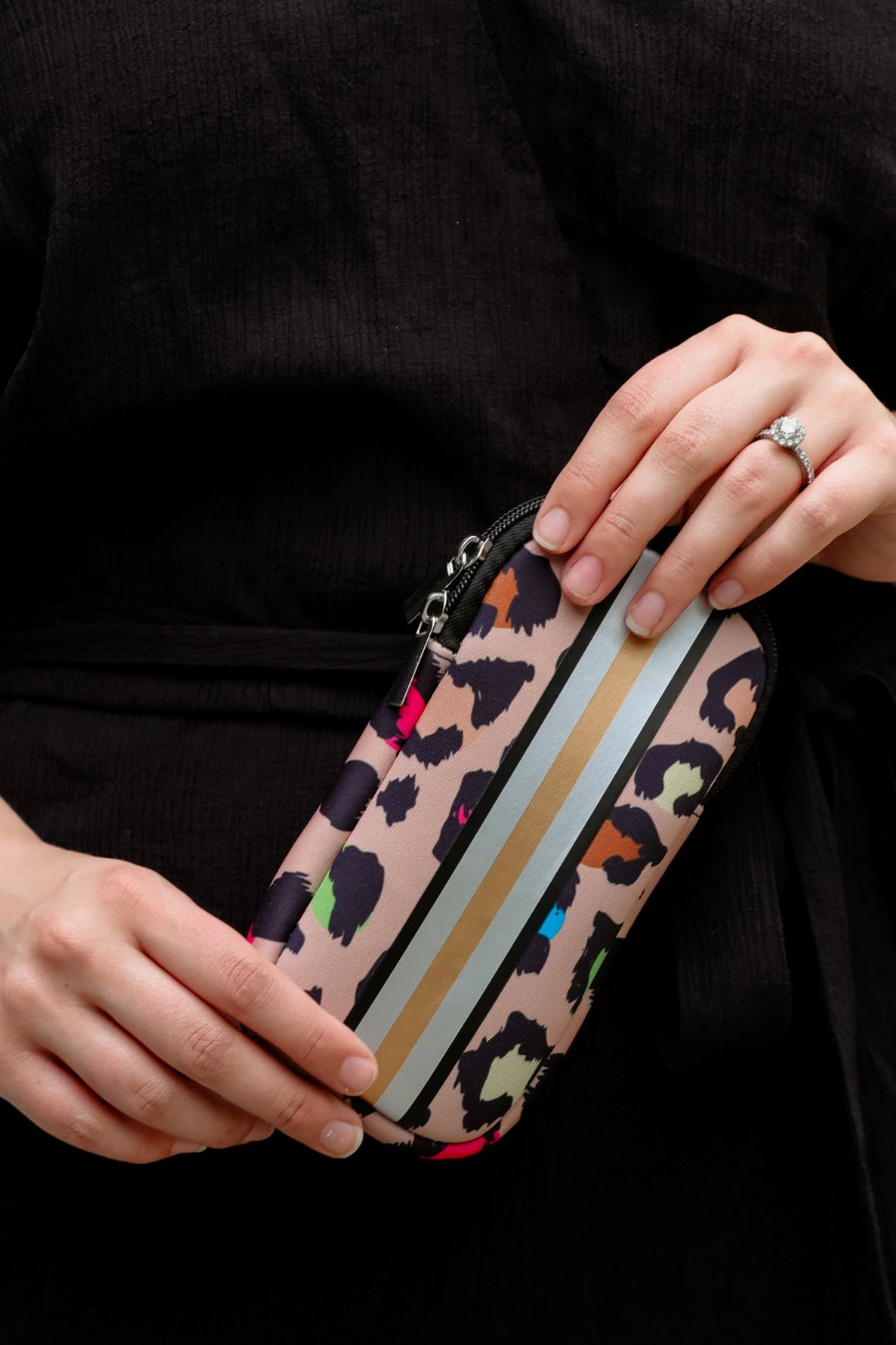 ultra-lightweight sunglasses case made of neoprene with a top double zipper in silver hardware and corresponding racing stripes in multi leopard