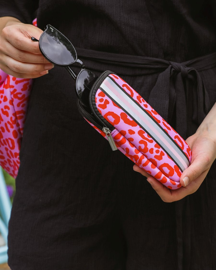 ultra-lightweight sunglasses case made of neoprene with a top double zipper in silver hardware and corresponding racing stripes in pink leopard