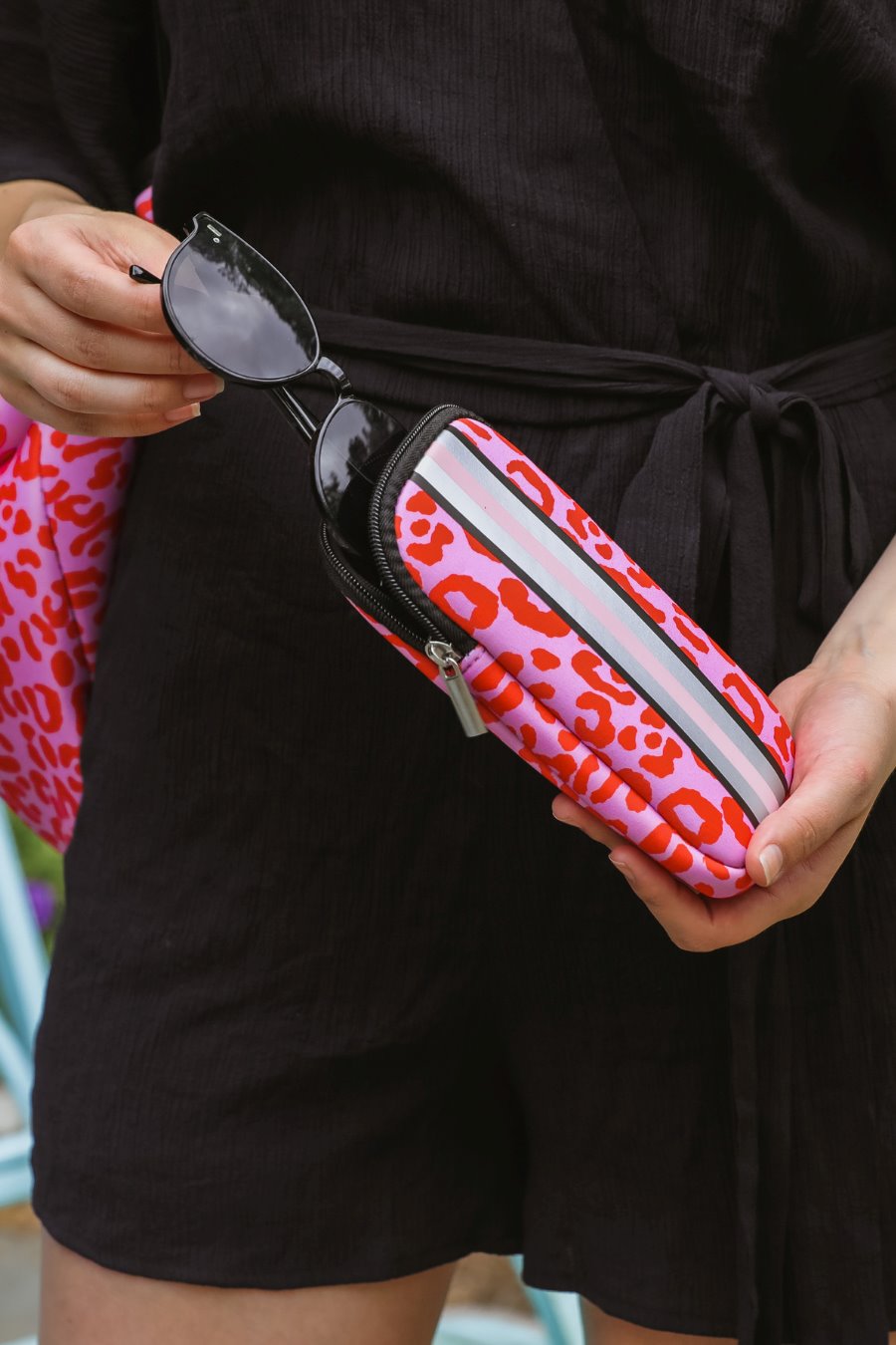 ultra-lightweight sunglasses case made of neoprene with a top double zipper in silver hardware and corresponding racing stripes in pink leopard