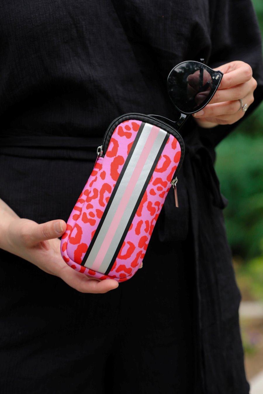 ultra-lightweight sunglasses case made of neoprene with a top double zipper in silver hardware and corresponding racing stripes in pink leopard