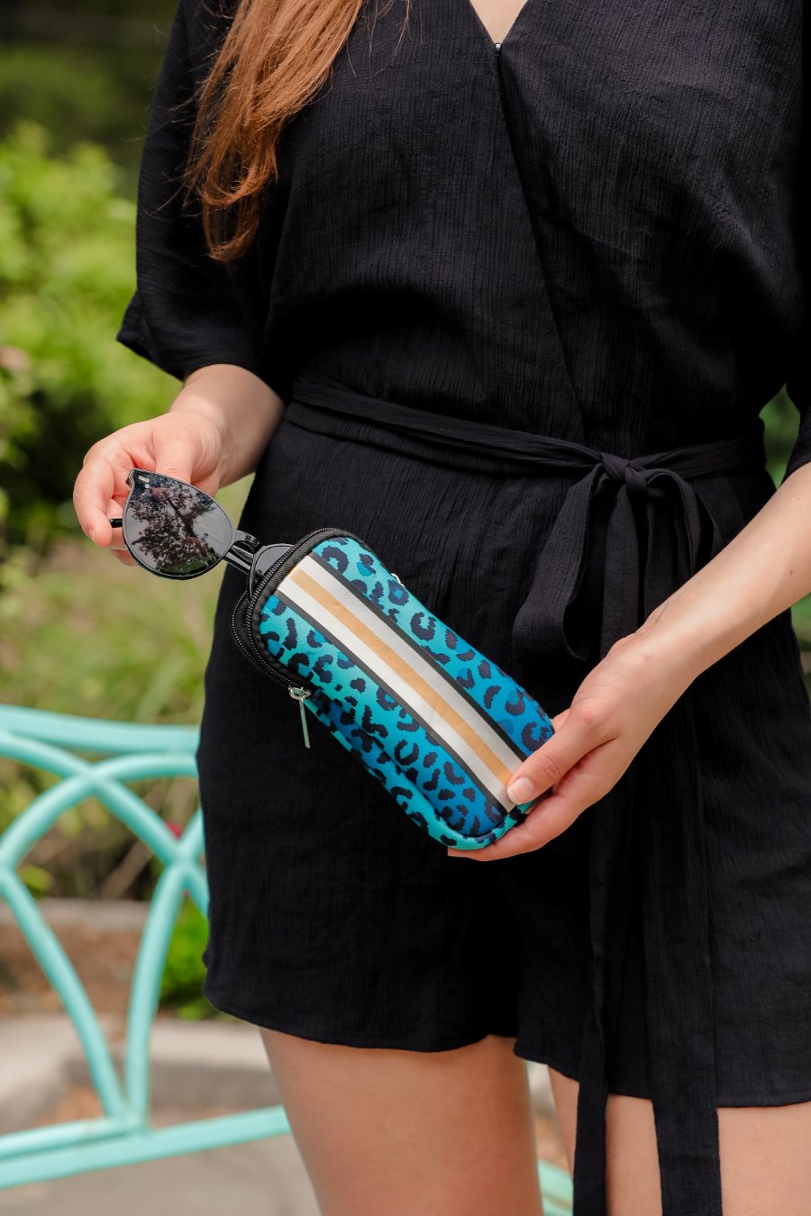 ultra-lightweight sunglasses case made of neoprene with a top double zipper in silver hardware and corresponding racing stripes in turquoise leopard