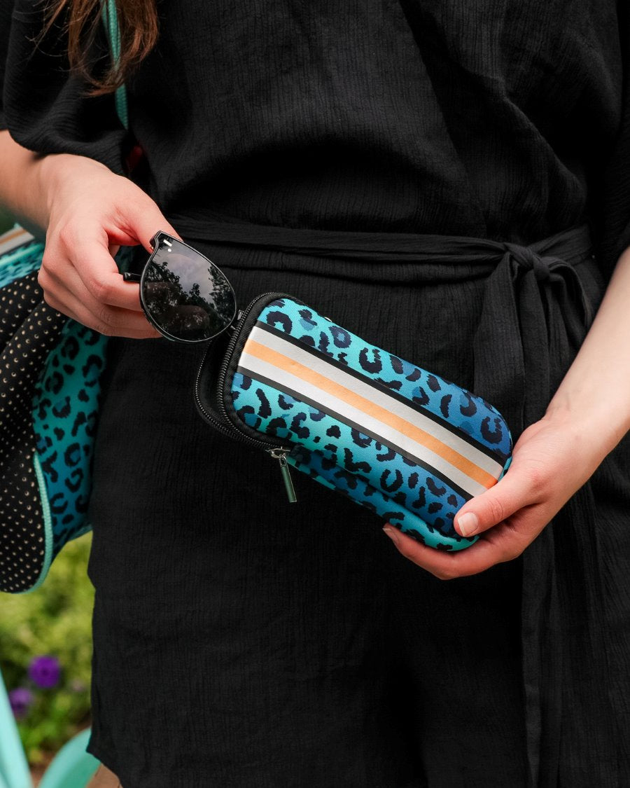 ultra-lightweight sunglasses case made of neoprene with a top double zipper in silver hardware and corresponding racing stripes in turquoise leopard