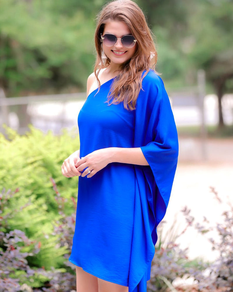 a royal blue one-shoulder mini dress with an asymmetrical neckline and a draping, billowy body creating a relaxed silhouette