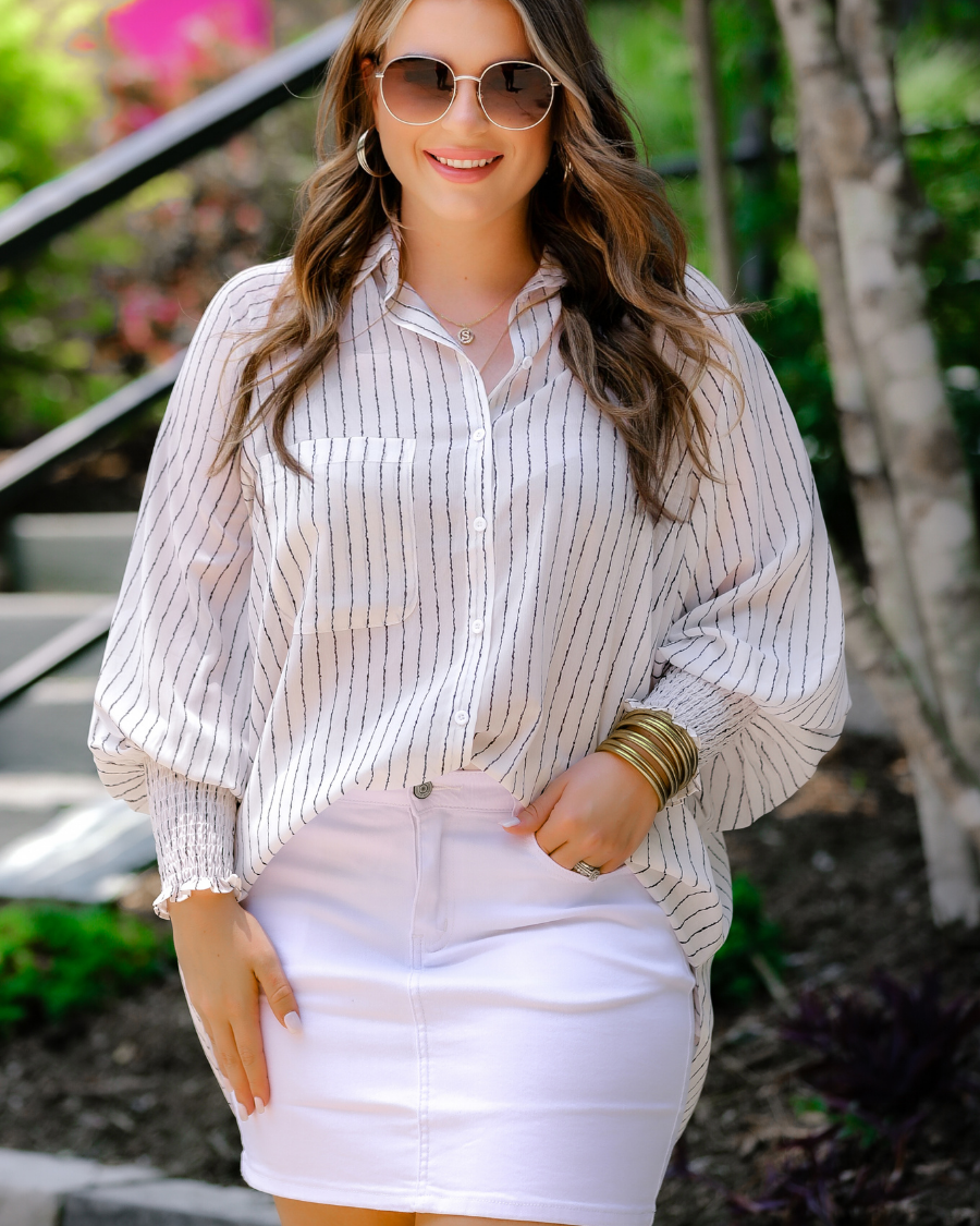 a classic white denim skirt with a little stretch, five-pocket style, and a zip fly with button closure
