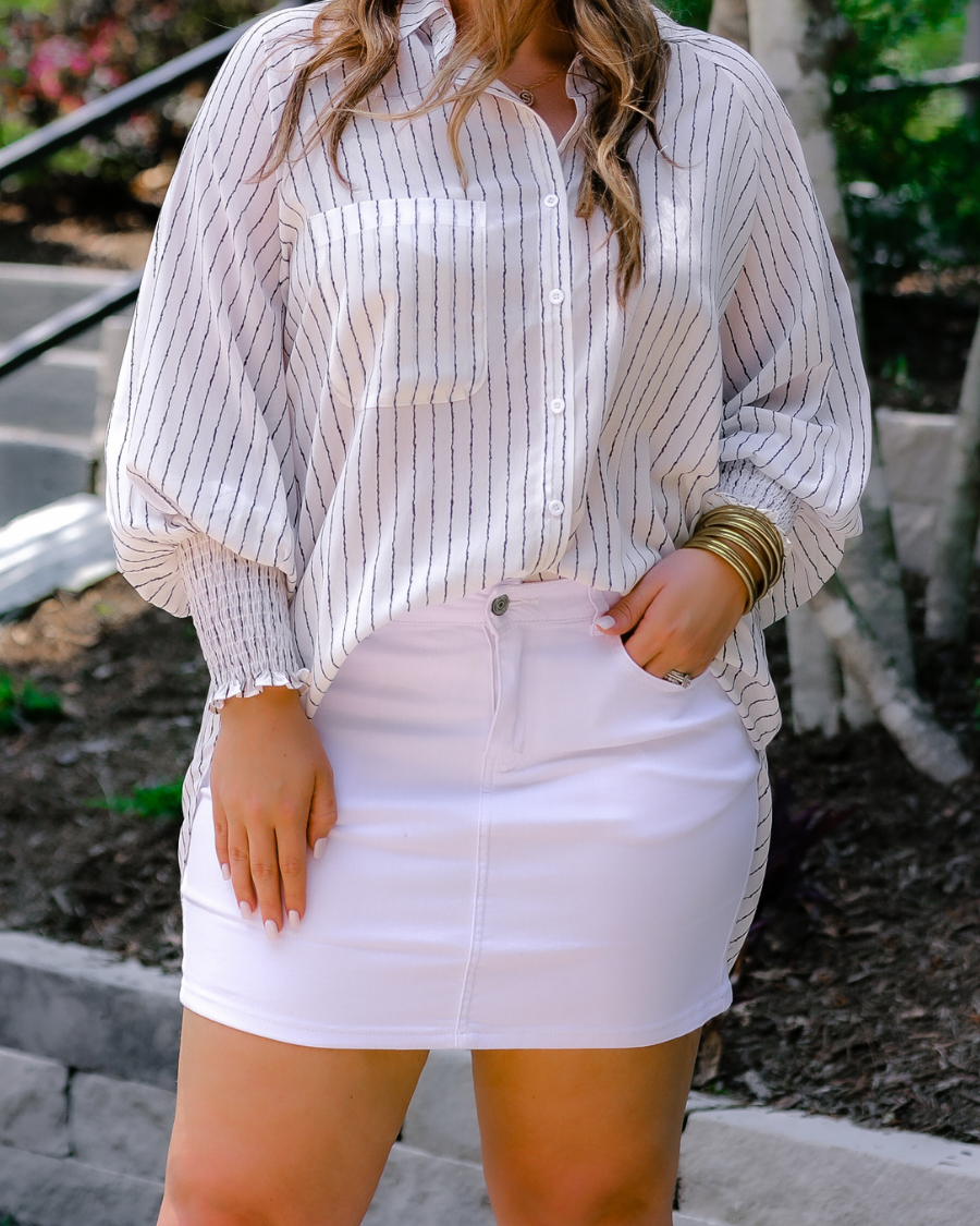 a classic white denim skirt with a little stretch, five-pocket style, and a zip fly with button closure