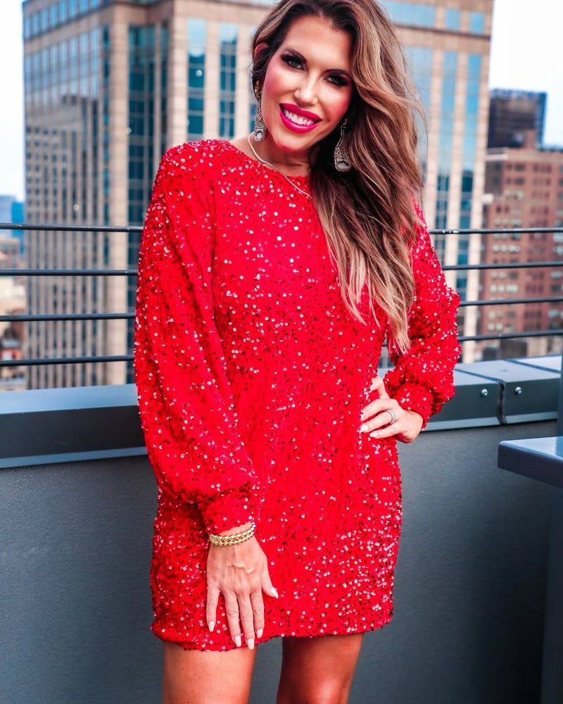 a red long balloon sleeve dress made of sparkly allover sequins, luxe velvet underlay, a keyhole accented upper back with button closure, a round neckline, and subtle elastic cuffs