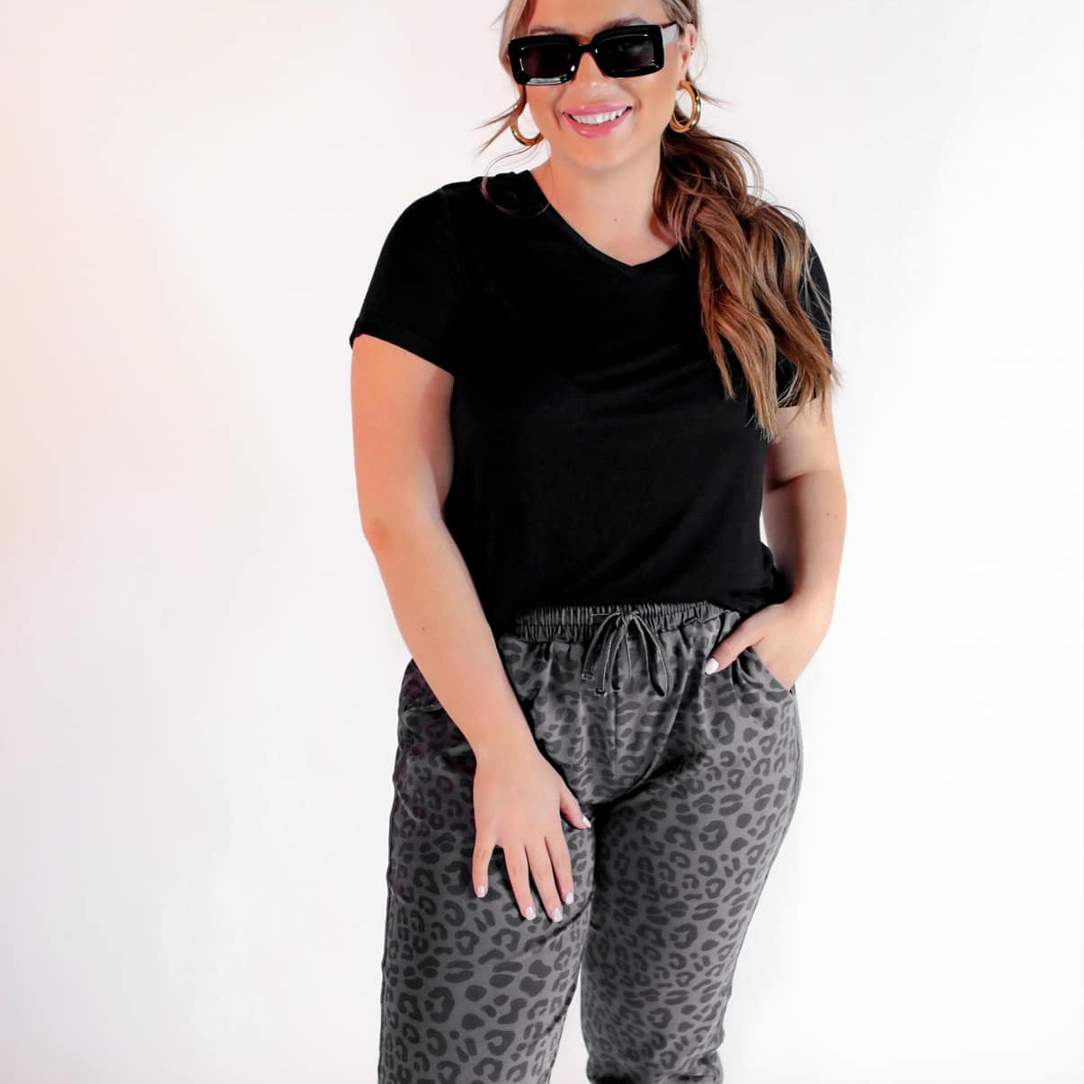a mid-rise relaxed fit joggers with side pockets and a tie waist drawstring, designed on a black-on-black leopard pattern print and black base