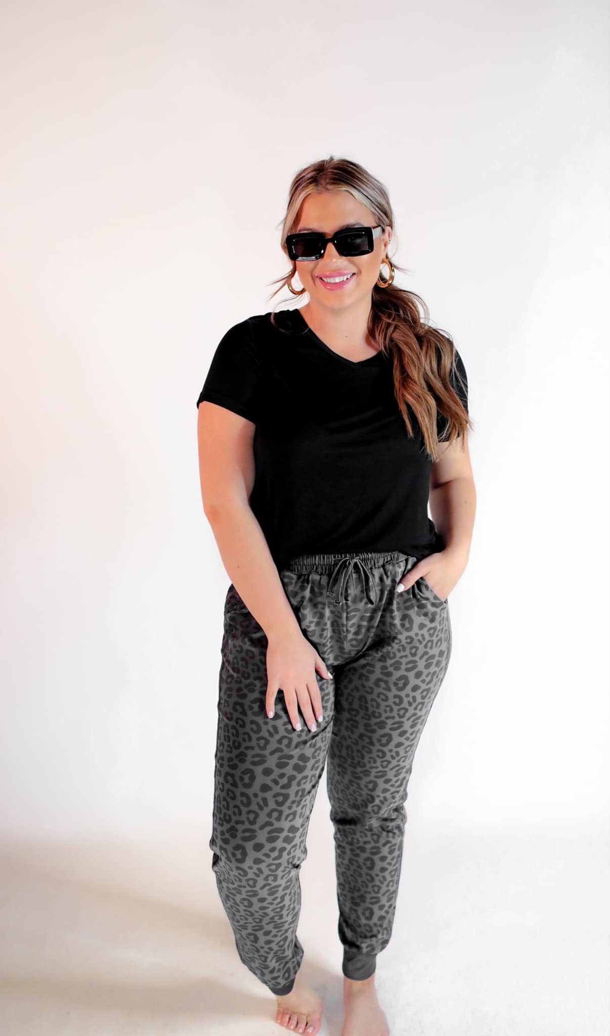 a mid-rise relaxed fit joggers with side pockets and a tie waist drawstring, designed on a black-on-black leopard pattern print and black base