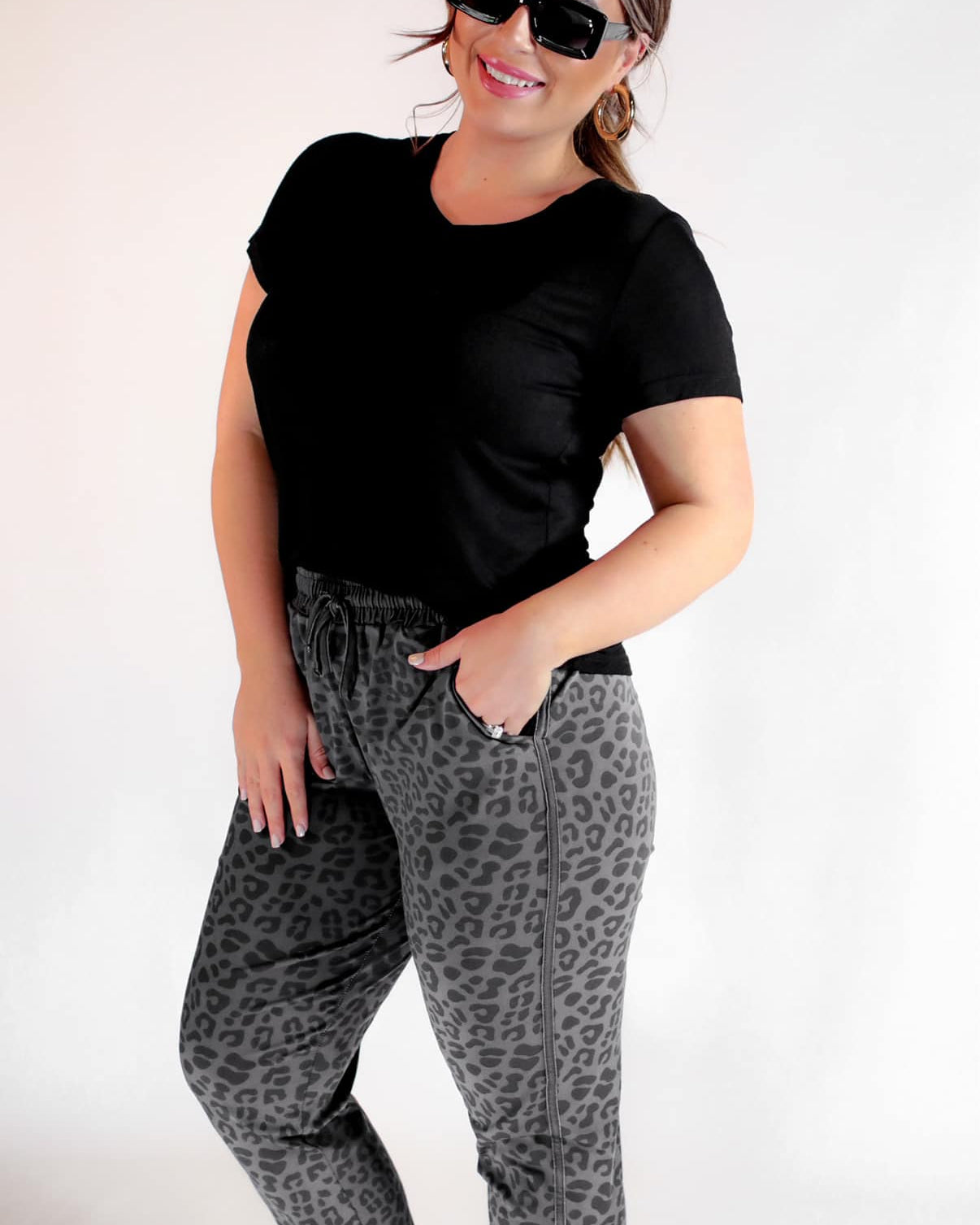a mid-rise relaxed fit joggers with side pockets and a tie waist drawstring, designed on a black-on-black leopard pattern print and black base