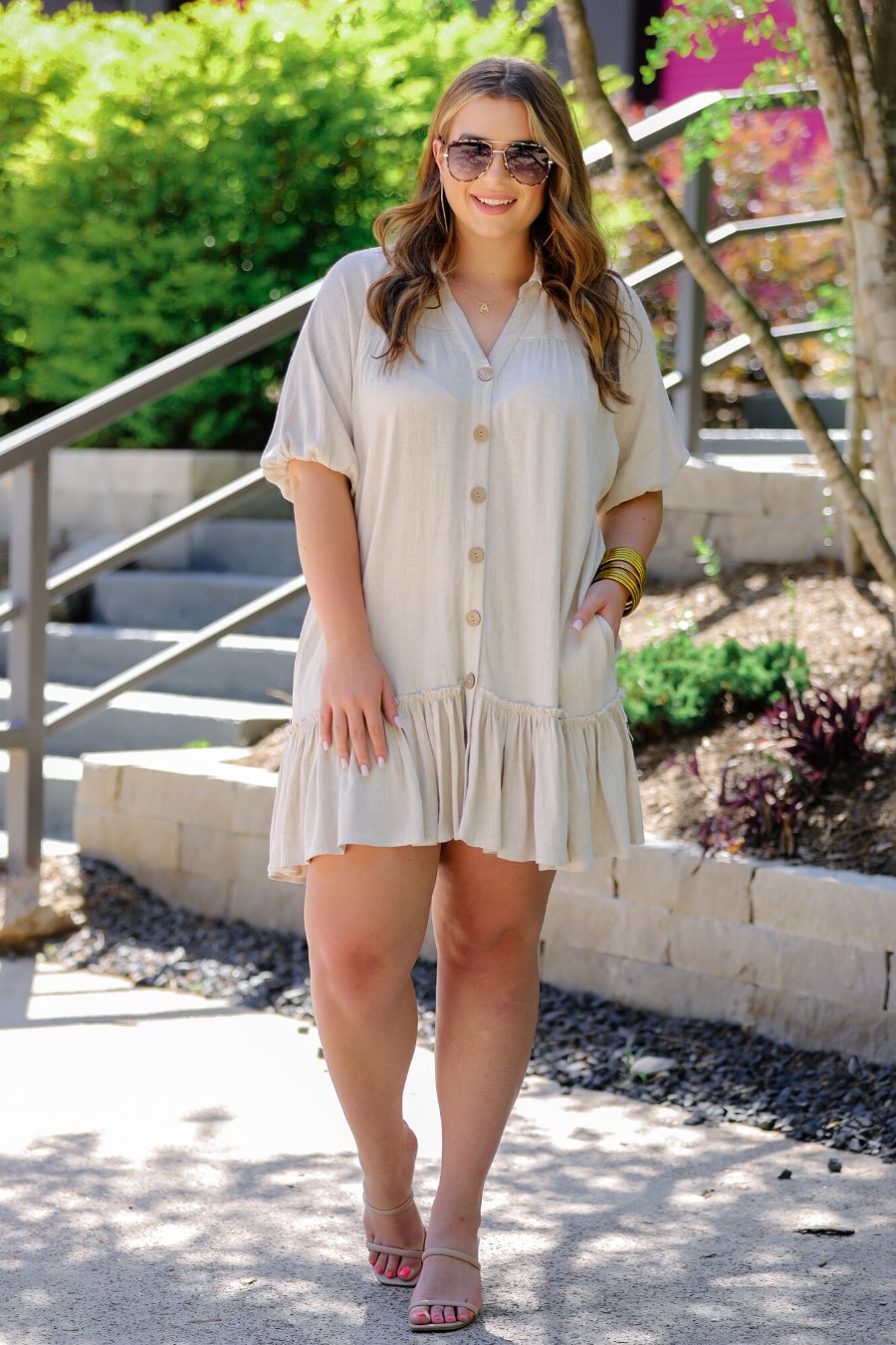 relaxed short-sleeve dress with a V-cut collar, full-button front closure, side pockets, and tiered ruffled hemline in oatmeal