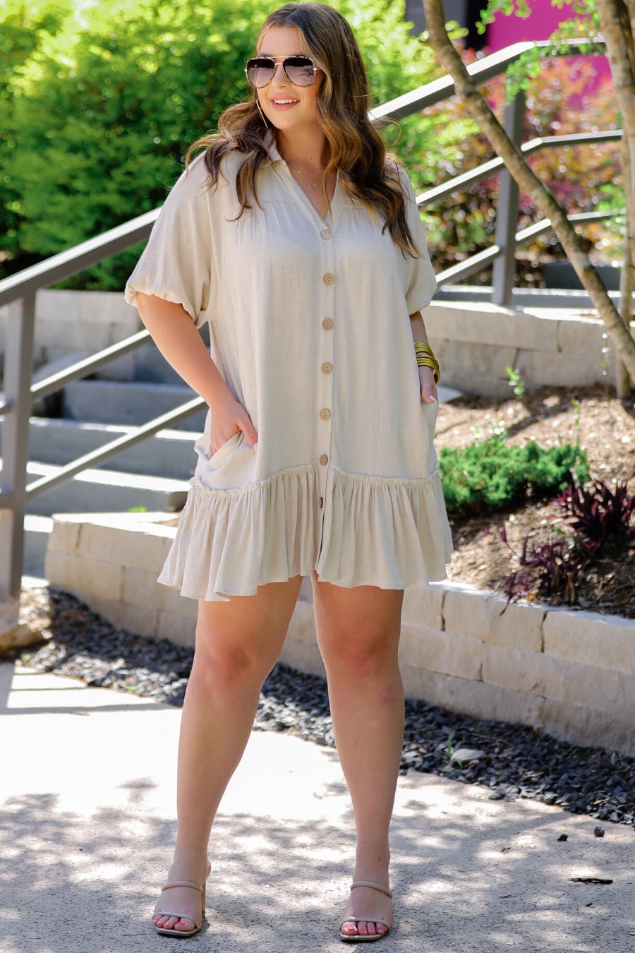 relaxed short-sleeve dress with a V-cut collar, full-button front closure, side pockets, and tiered ruffled hemline in oatmeal