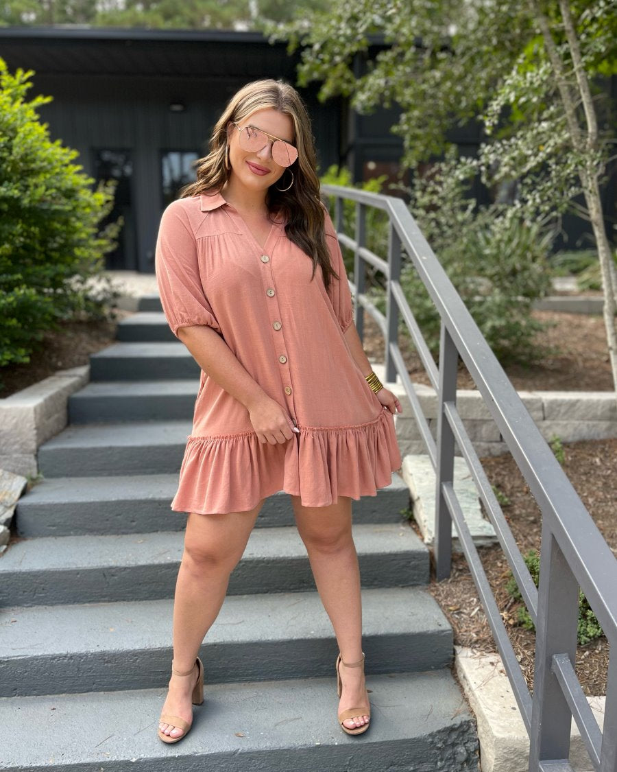 relaxed short-sleeve dress with a V-cut collar, full-button front closure, side pockets, and tiered ruffled hemline in apricot
