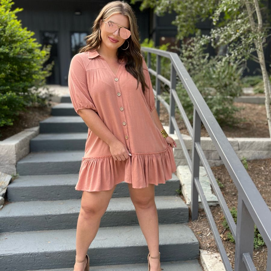 relaxed short-sleeve dress with a V-cut collar, full-button front closure, side pockets, and tiered ruffled hemline in apricot