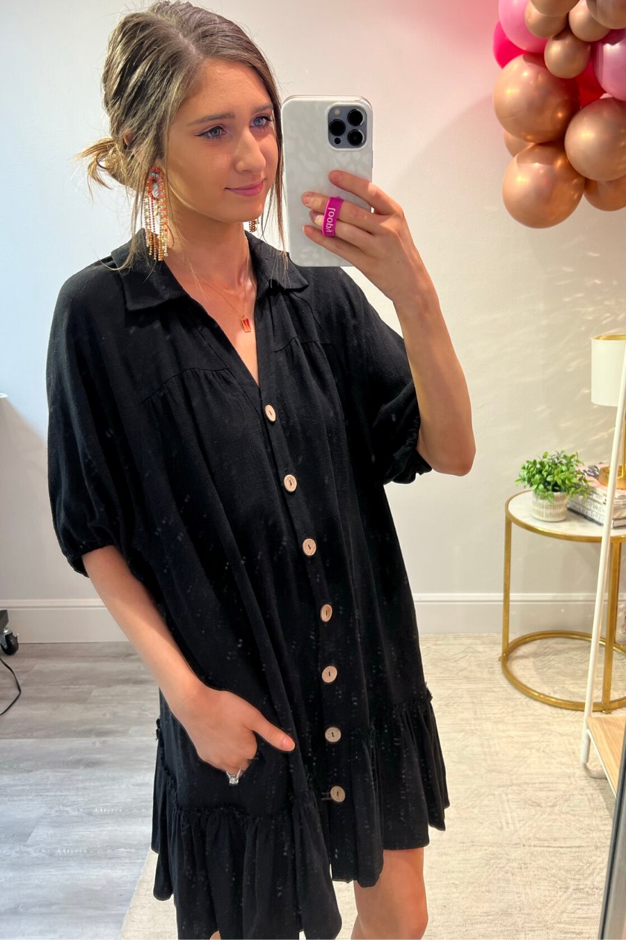 relaxed short-sleeve dress with a V-cut collar, full-button front closure, side pockets, and tiered ruffled hemline in black