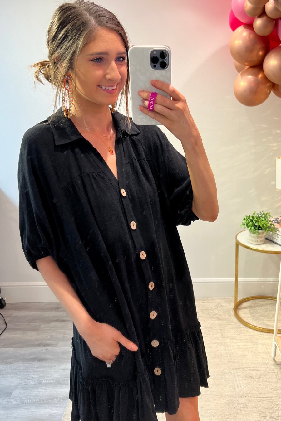 relaxed short-sleeve dress with a V-cut collar, full-button front closure, side pockets, and tiered ruffled hemline in black