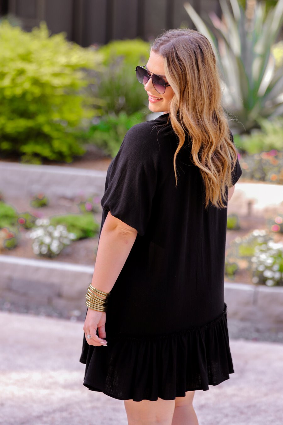 relaxed short-sleeve dress with a V-cut collar, full-button front closure, side pockets, and tiered ruffled hemline in black