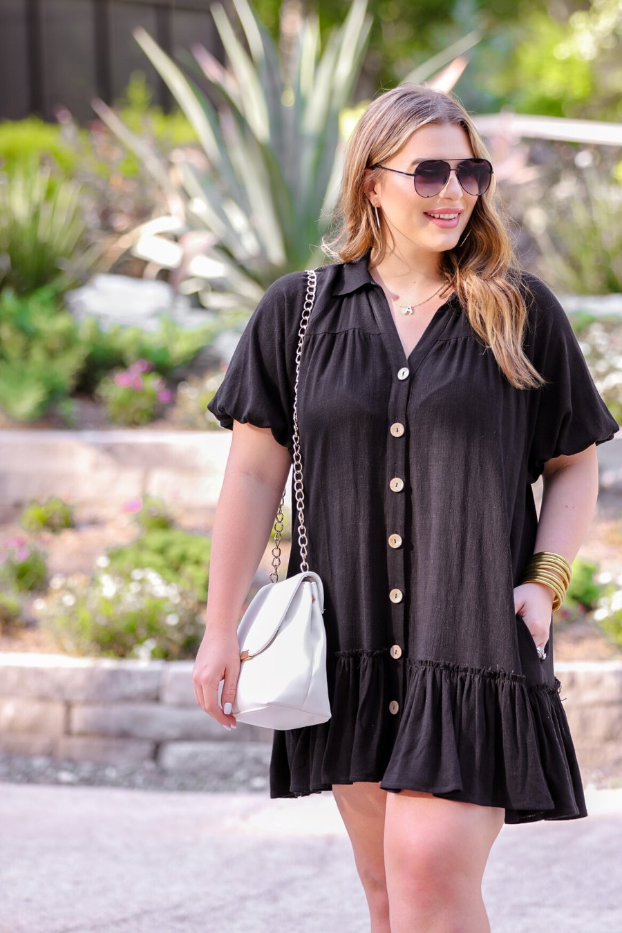 relaxed short-sleeve dress with a V-cut collar, full-button front closure, side pockets, and tiered ruffled hemline in black