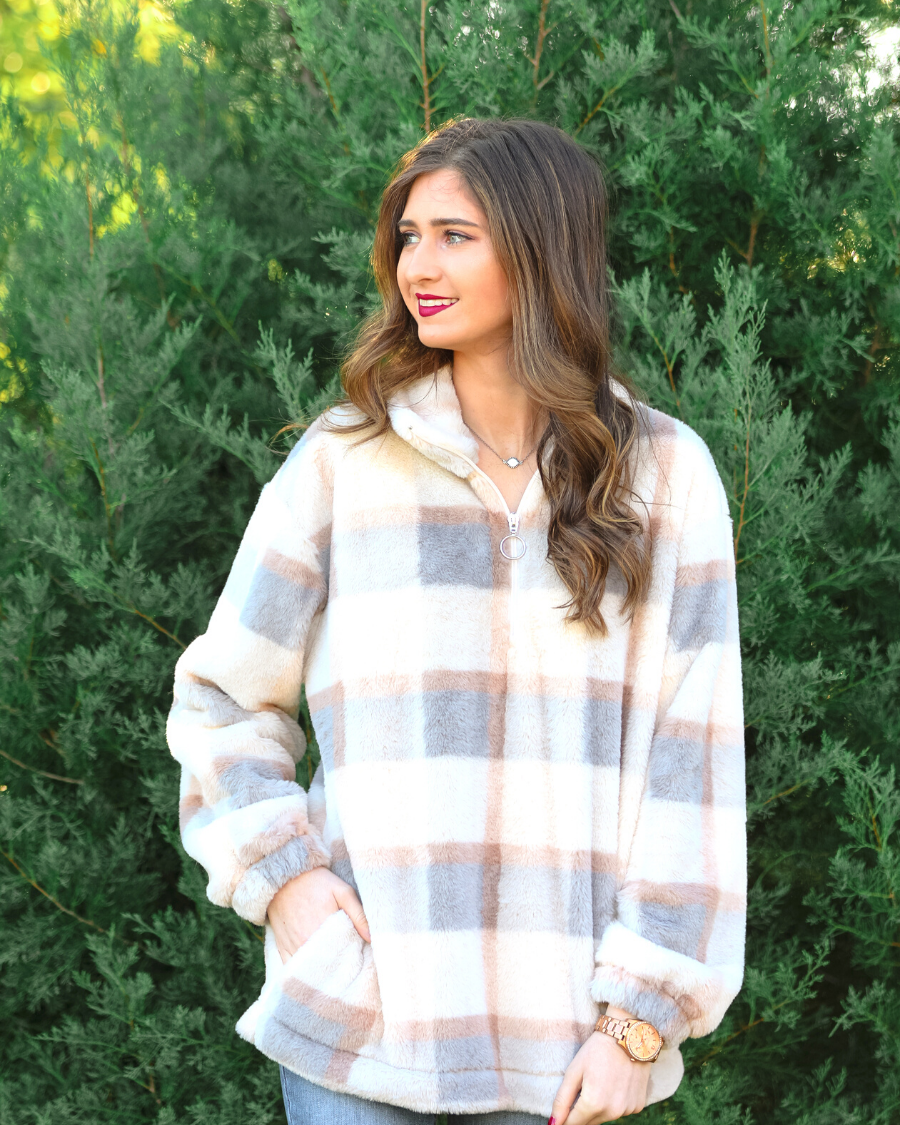 a taupe long-sleeve pullover with a neutral plaid pattern, a quarter zip, a foldable collar, and pockets made of a super soft material