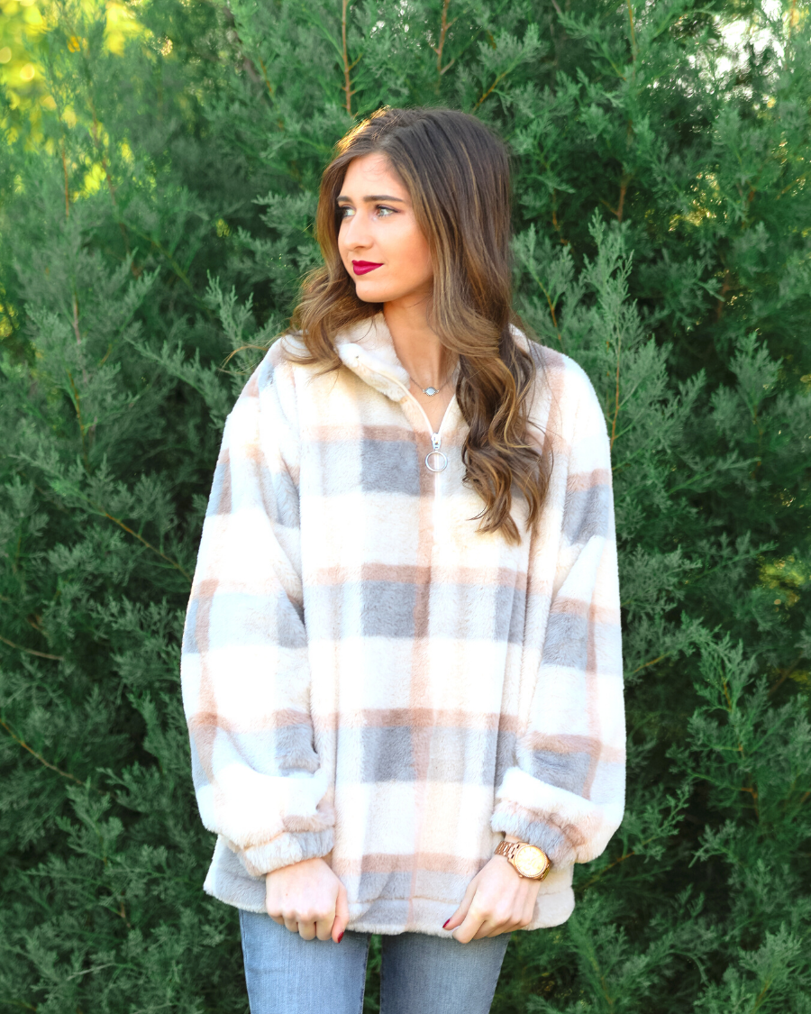 a taupe long-sleeve pullover with a neutral plaid pattern, a quarter zip, a foldable collar, and pockets made of a super soft material