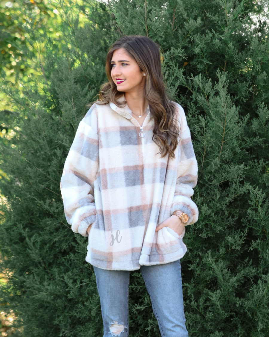 a taupe long-sleeve pullover with a neutral plaid pattern, a quarter zip, a foldable collar, and pockets made of a super soft material