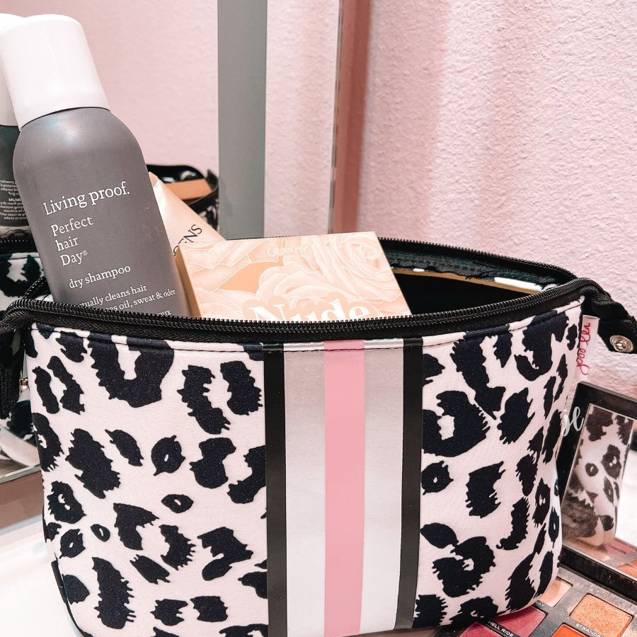 neoprene cosmetic bag in a black and pink leopard print with dual top zippers (black), expandable side snaps (silver), and racing stripes (black, gray, and pink)