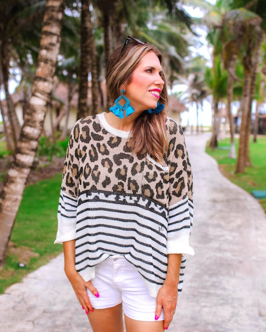 three-quarter cuffed sleeve unlined sweater crafted from loose knit material with an oversized fit, a rounded neckline, a chest pocket, and trim on the collar, hem, and pocket on a mix of leopard print (black, brown, and cream) and vertical stripes (black and ivory)