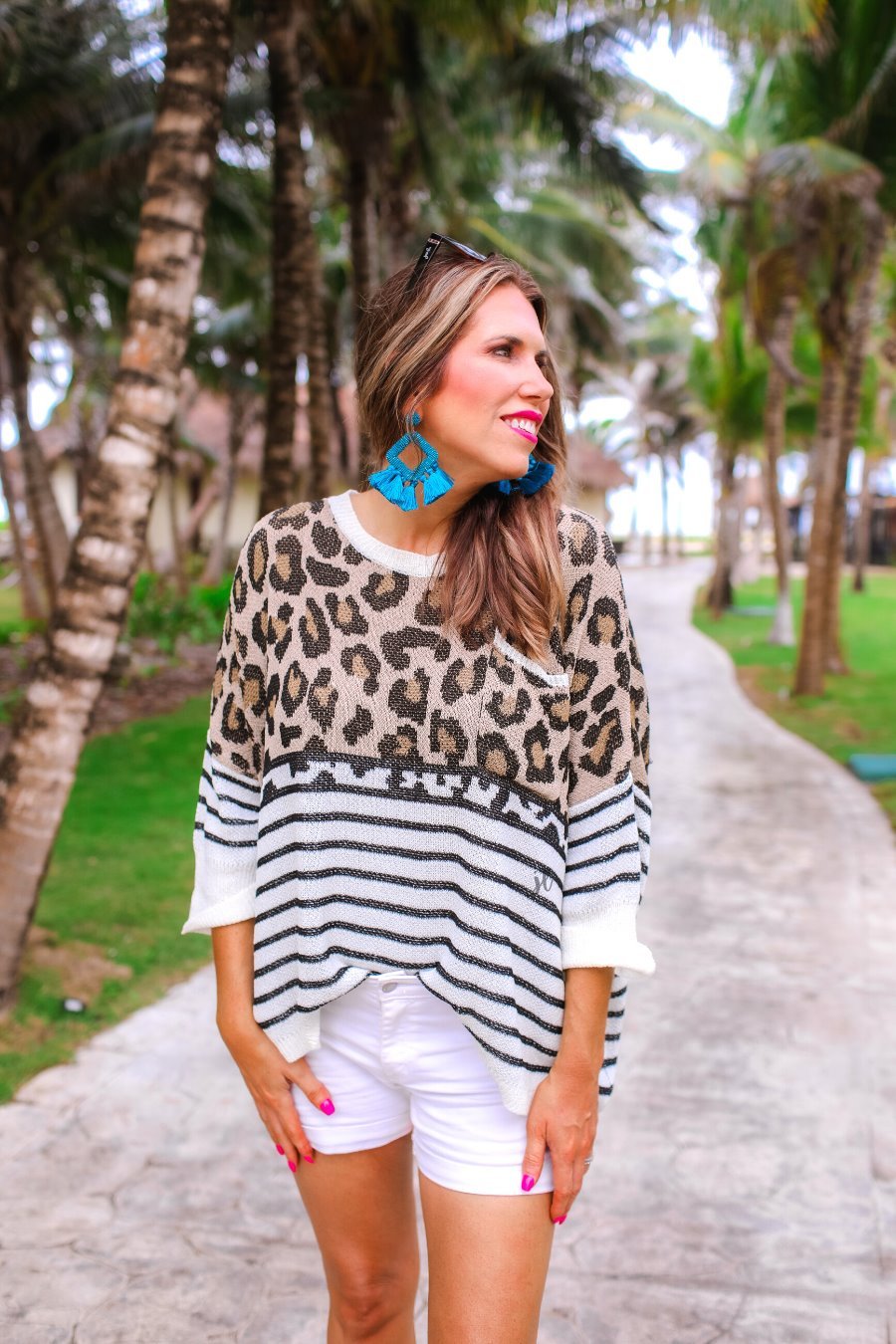 three-quarter cuffed sleeve unlined sweater crafted from loose knit material with an oversized fit, a rounded neckline, a chest pocket, and trim on the collar, hem, and pocket on a mix of leopard print (black, brown, and cream) and vertical stripes (black and ivory)