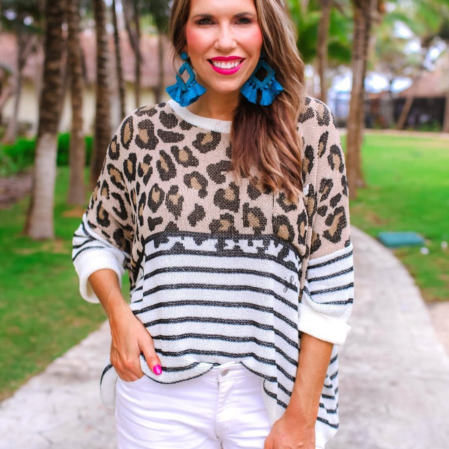 three-quarter cuffed sleeve unlined sweater crafted from loose knit material with an oversized fit, a rounded neckline, a chest pocket, and trim on the collar, hem, and pocket on a mix of leopard print (black, brown, and cream) and vertical stripes (black and ivory)