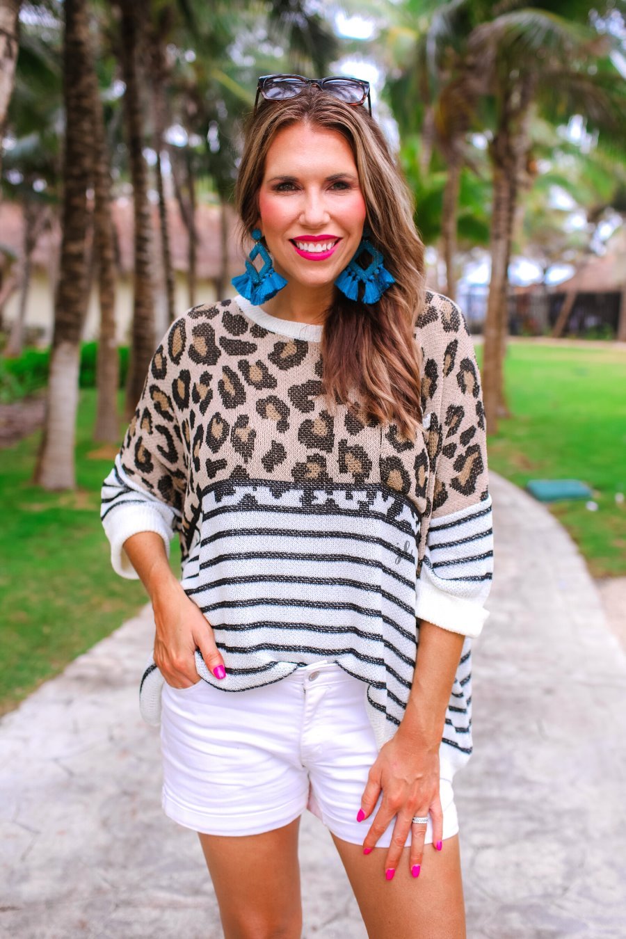 three-quarter cuffed sleeve unlined sweater crafted from loose knit material with an oversized fit, a rounded neckline, a chest pocket, and trim on the collar, hem, and pocket on a mix of leopard print (black, brown, and cream) and vertical stripes (black and ivory)