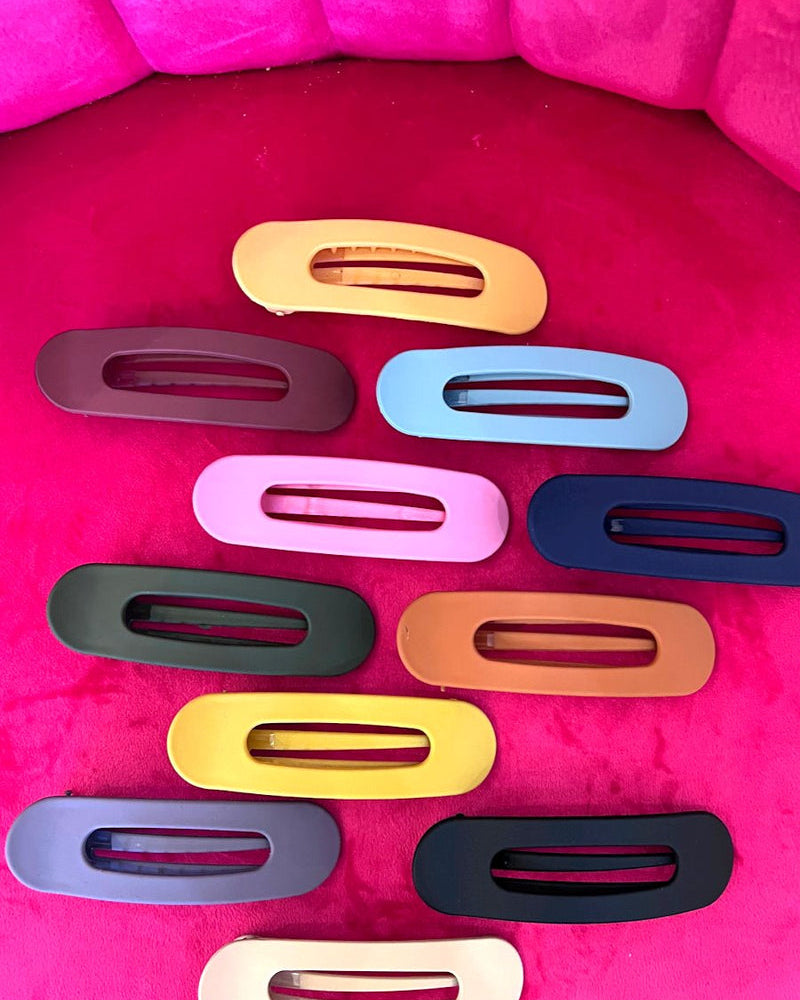 Raeh oversized spring back clip with curve design in black, blue, burgundy, hunter green, mustard, navy, neutral, peach, pink, purple, and terracotta