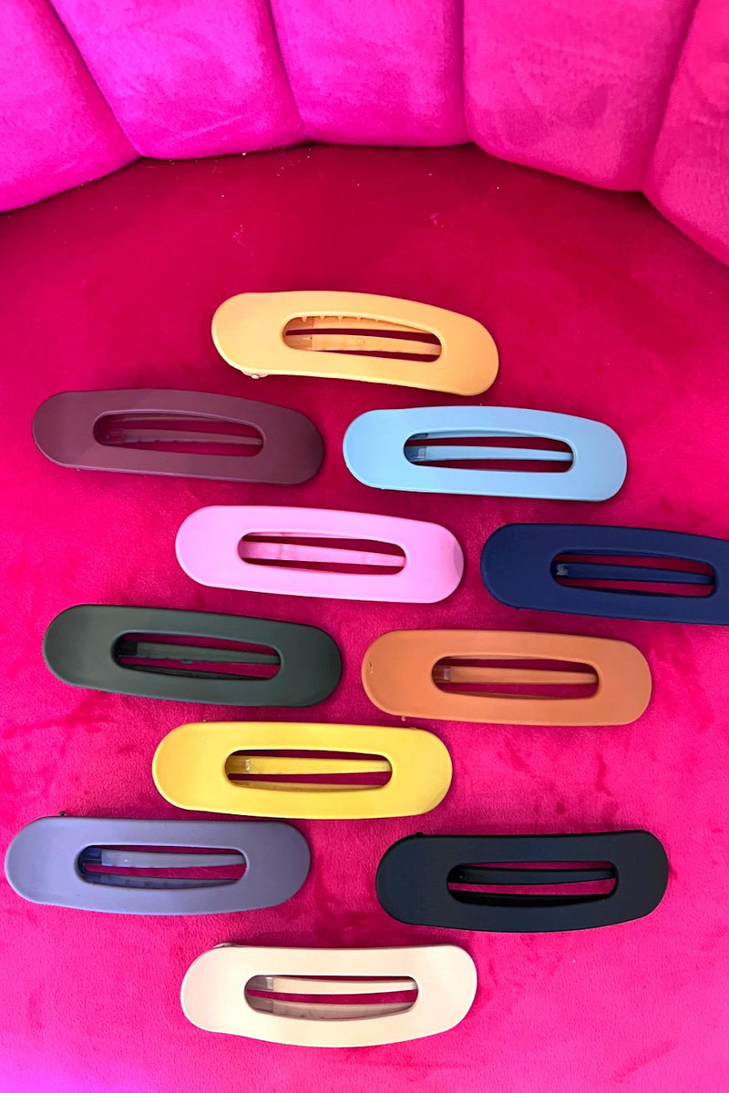 Raeh oversized spring back clip with curve design in black, blue, burgundy, hunter green, mustard, navy, neutral, peach, pink, purple, and terracotta