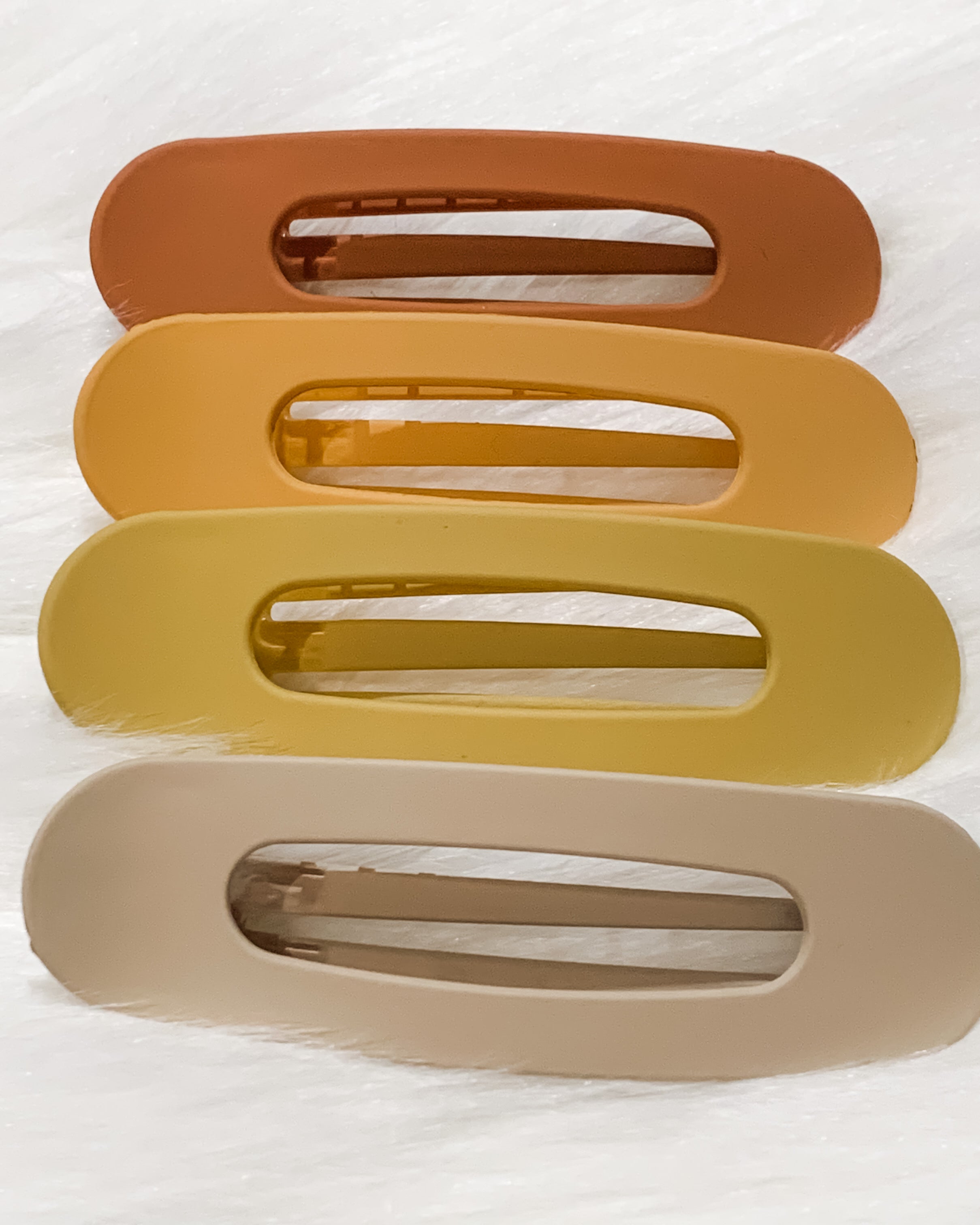 oversized spring back clip with curve design in terracotta, peach, mustard, and neutral