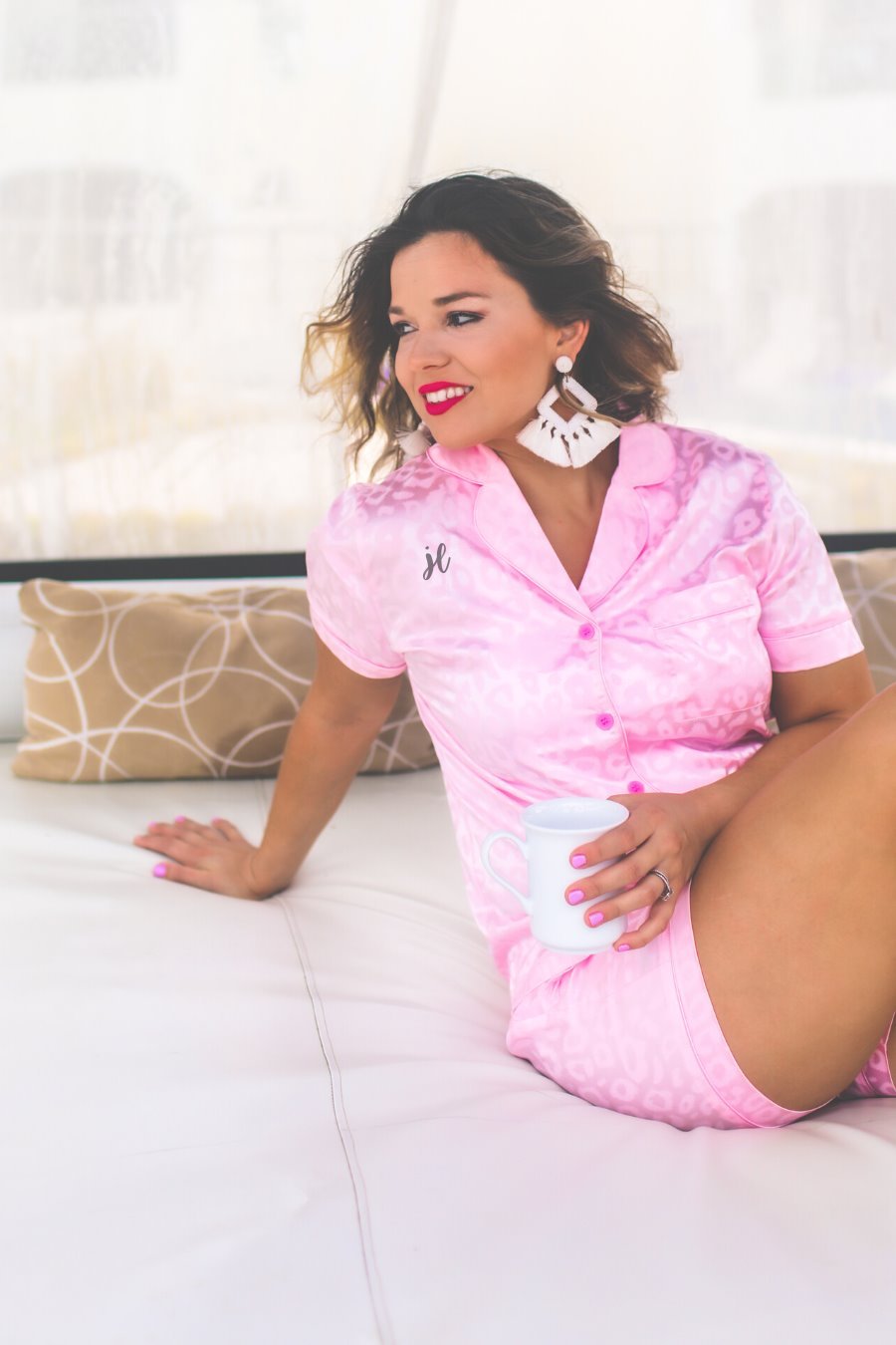 a pink satin two-piece lounge set sold together with a tonal leopard pattern, collared button-down top, short sleeves, a chest pocket, piped trim, and matching shorts with an elastic drawstring waist and accent side pockets