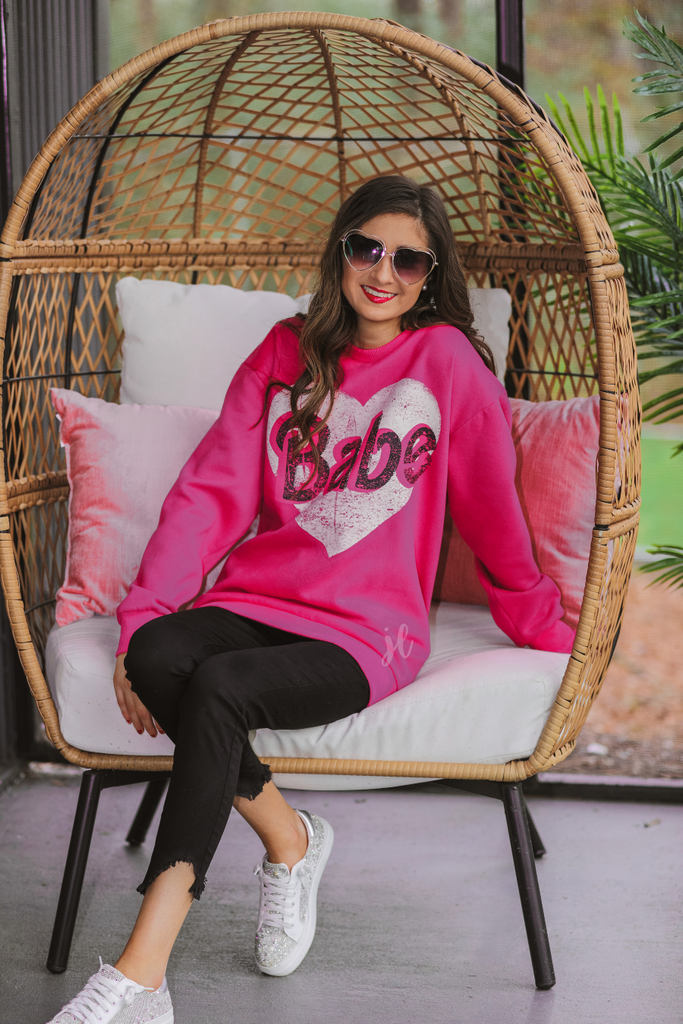 a soft material with a cute front vintage heart graphic, a rounded neckline, long sleeves, & a relaxed silhouette that falls into a straight hemline hemline