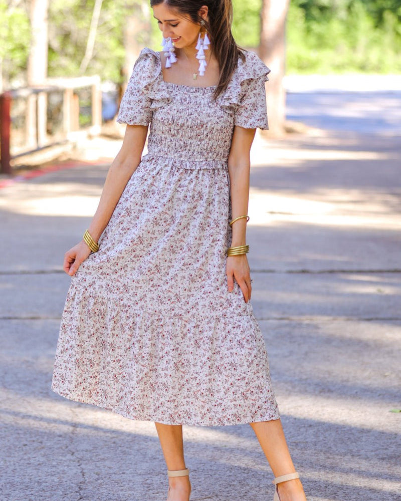 a lightweight ditsy floral midi dress with a smocked bodice, square neckline, ruffled trim and cap sleeves (wearable on or off the shoulder), and a relaxed silhouette that falls into a mid-calf hemline